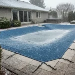 une piscine enterrée sous une bâche l'hiver pendant qu'il neige