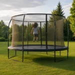 Un trampoline de jardin dont le filet est entièrement fermé, avec un seul enfant en train de sauter à l'intérieur, vu de dos et à distance.