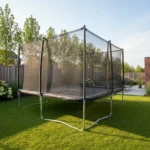 Un trampoline de jardin de forme rectangulaire posé sur une pelouse, avec son filet de sécurité fermé, vu de trois quarts.